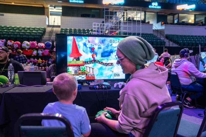 A Gamers For Giving attendee plays Super Smash Bros. with a kid